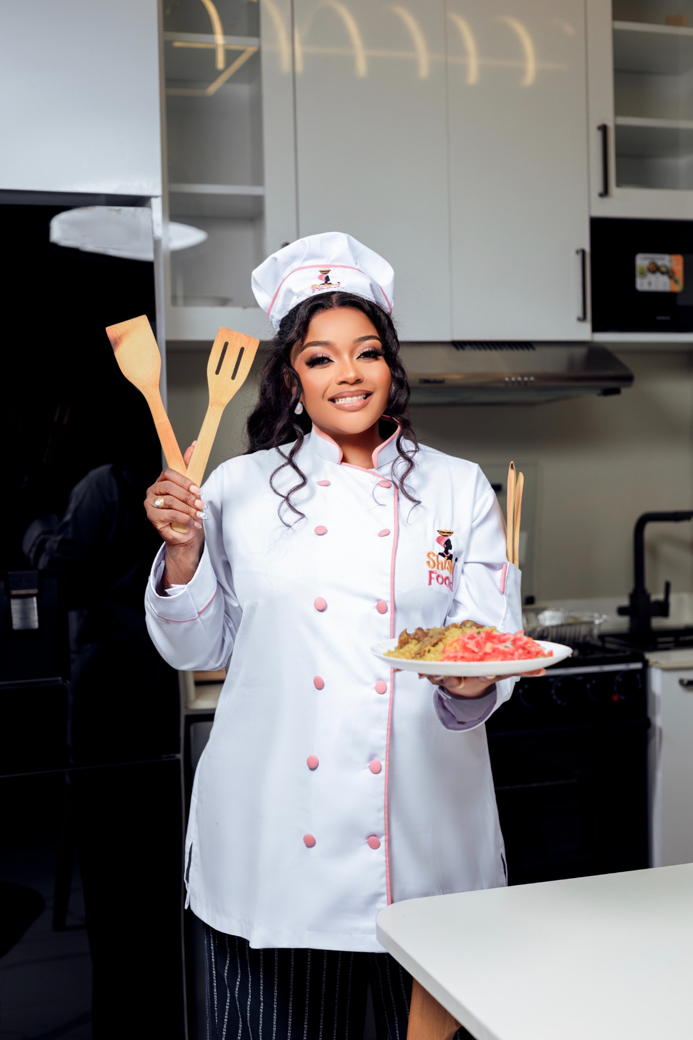 Smiling Shishi Food chef holding her signature dish